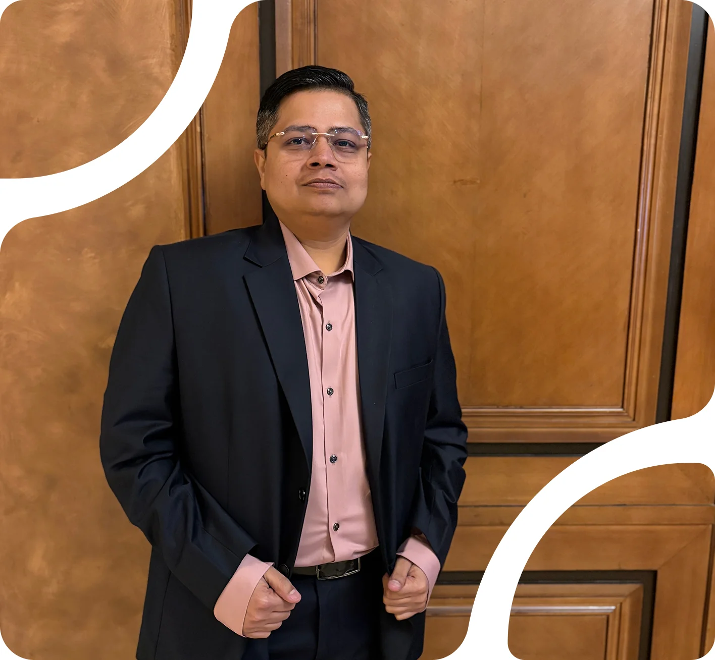 Jay Parekh in a formal suit against a wooden backdrop